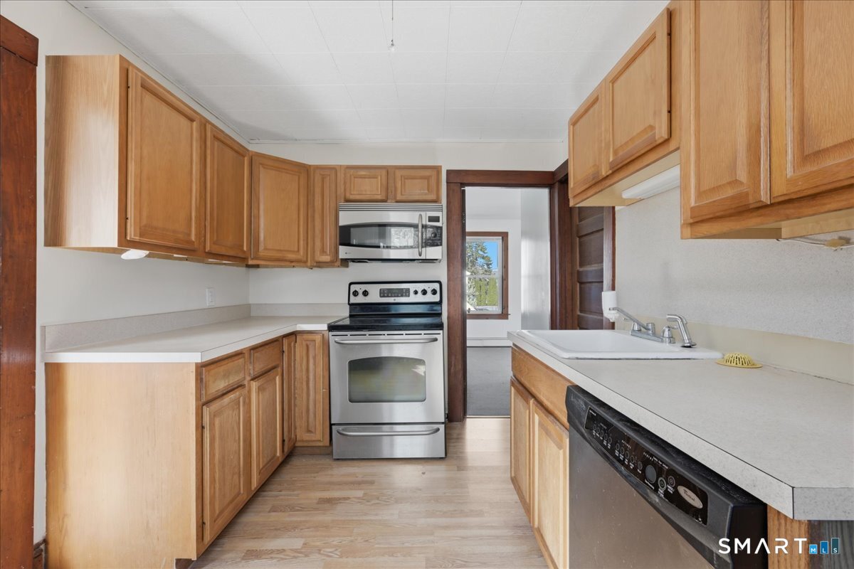 46 Hatch Street Stonington, CT 06355 - Photo 2 of 40 a kitchen with stainless steel appliances a sink dishwasher stove and refrigerator