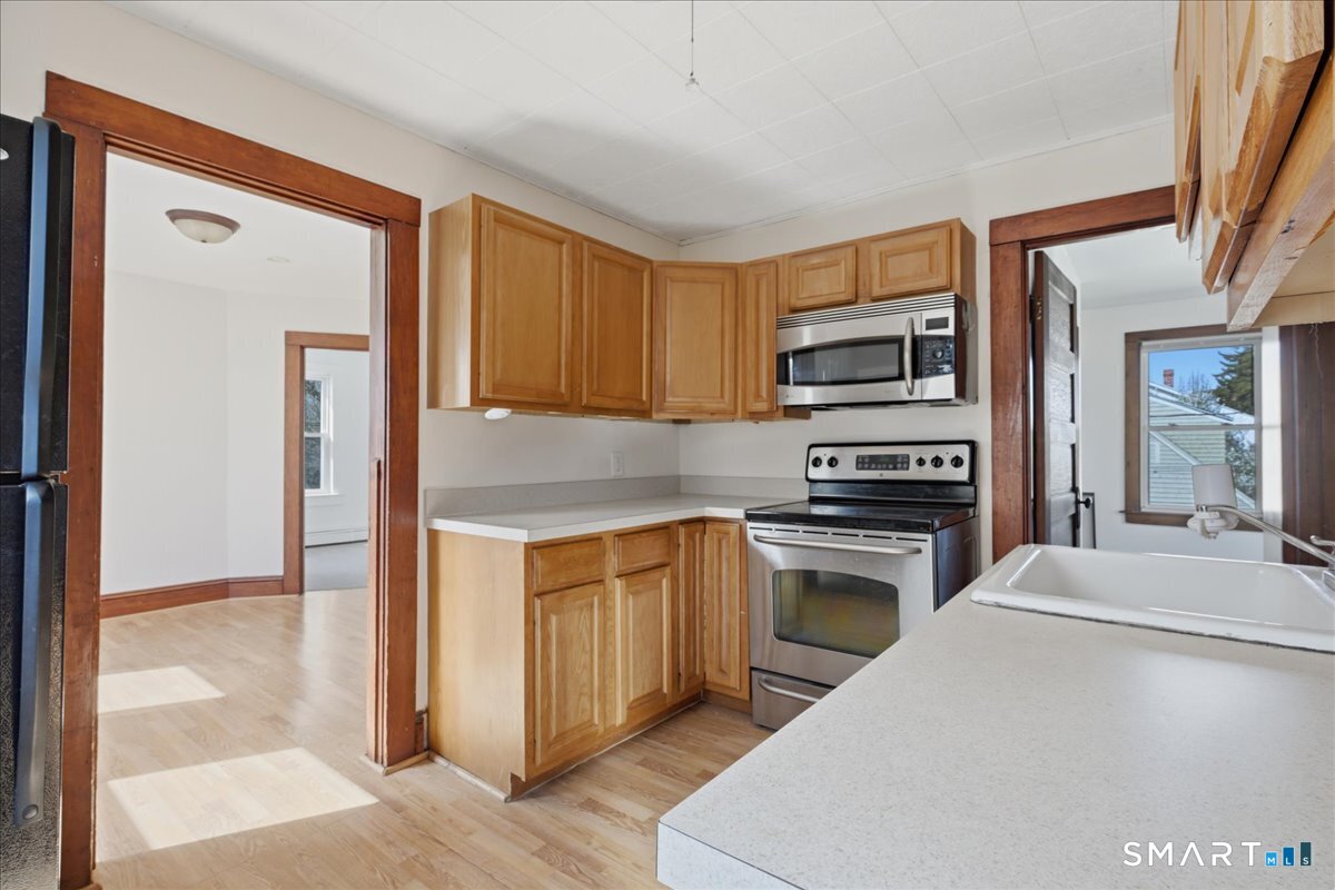 46 Hatch Street Stonington, CT 06355 - Photo 3 of 40 a kitchen with granite countertop a stove top oven and cabinets