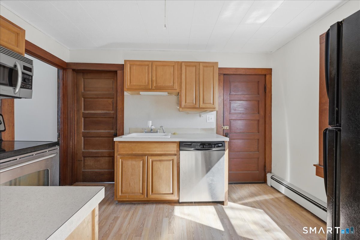 46 Hatch Street Stonington, CT 06355 - Photo 4 of 40 a kitchen with stainless steel appliances granite countertop a refrigerator a stove and a sink with wooden cabinets