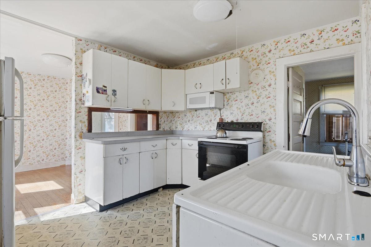 46 Hatch Street Stonington, CT 06355 - Photo 6 of 40 a kitchen with stainless steel appliances a stove a sink and a refrigerator