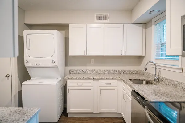 a view of a kitchen with sink and washer dryer