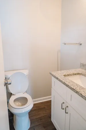 a bathroom with a granite countertop toilet and a sink