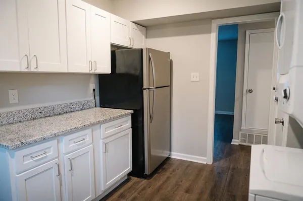 a kitchen with a refrigerator sink and cabinets