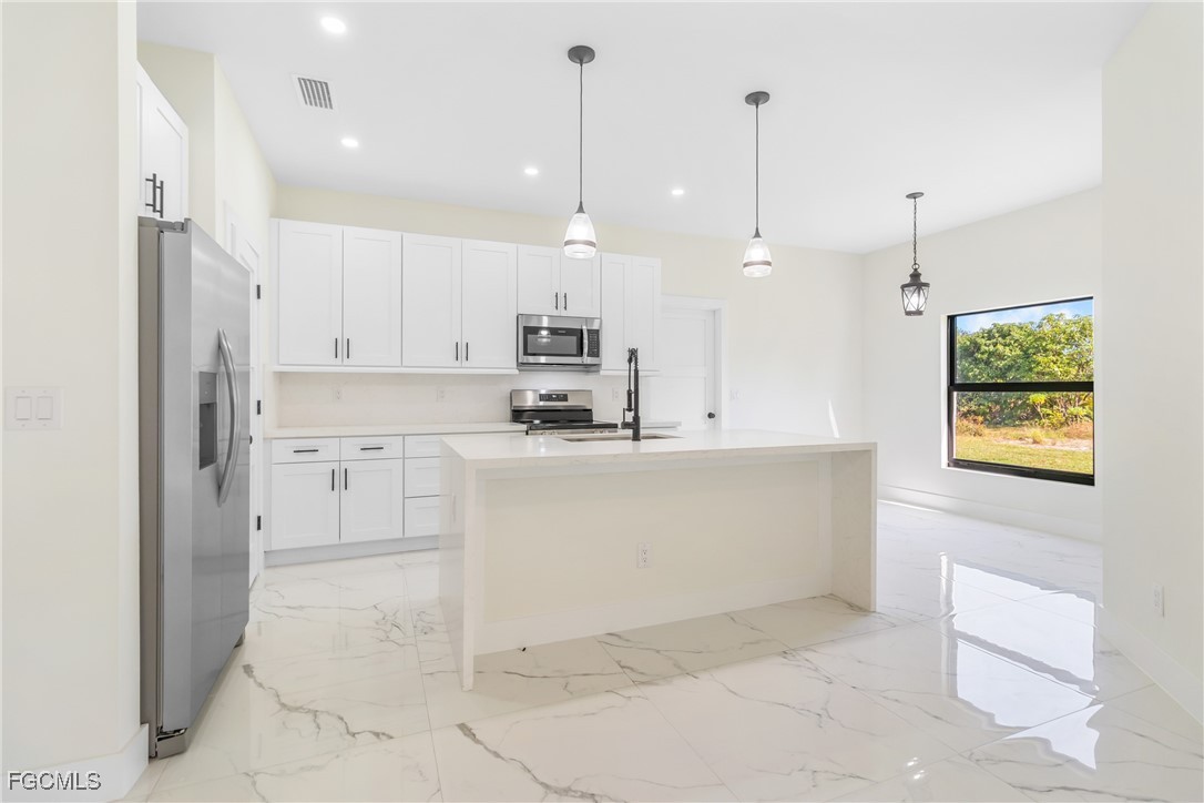 412 Fitch Avenue Lehigh Acres, FL 33972 - Photo 11 of 50 a view of kitchen with kitchen island white cabinets and stainless steel appliances