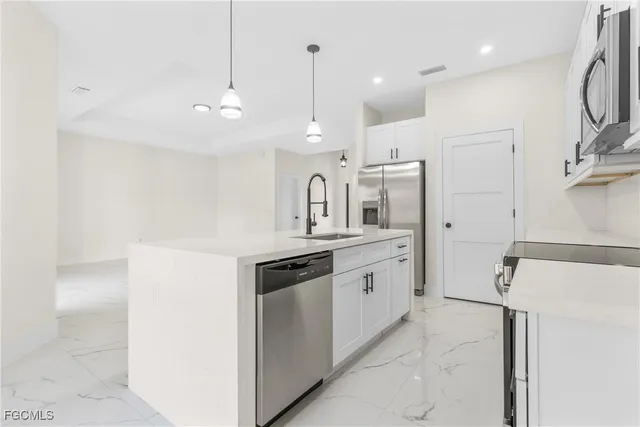 a kitchen with granite countertop a sink and a refrigerator