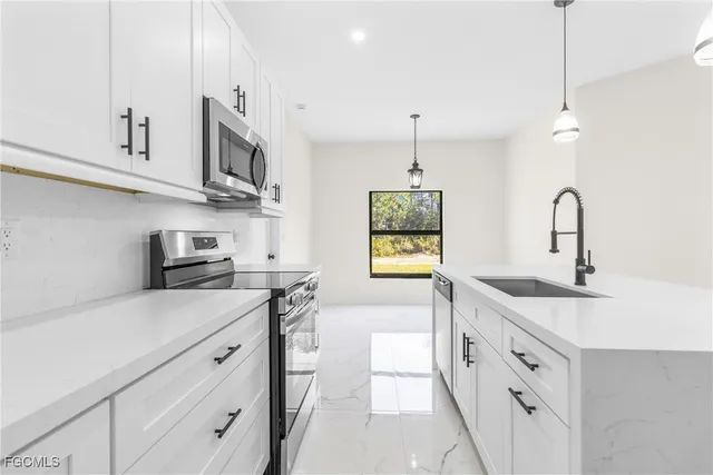 a kitchen with stainless steel appliances granite countertop a sink a stove and a wooden floors