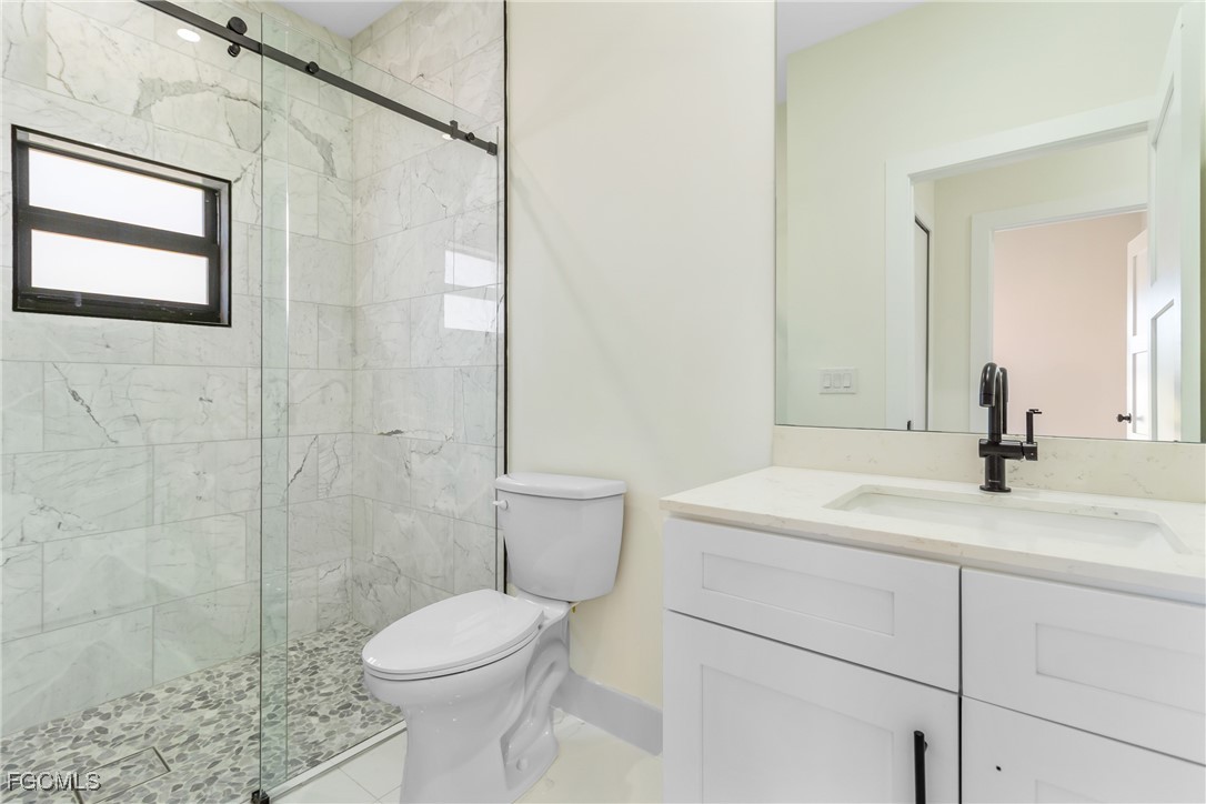 412 Fitch Avenue Lehigh Acres, FL 33972 - Photo 31 of 50 a bathroom with a sink a toilet and shower