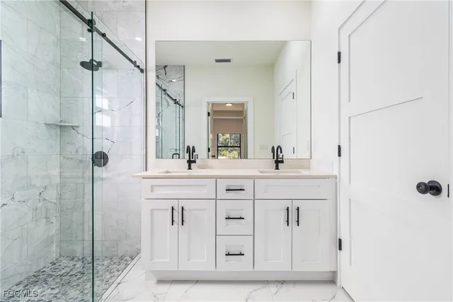 a bathroom with a shower sink and mirror