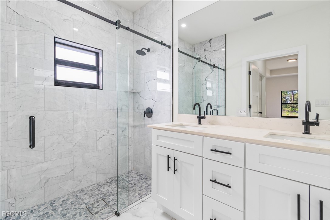 412 Fitch Avenue Lehigh Acres, FL 33972 - Photo 37 of 50 a bathroom with a shower sink and mirror