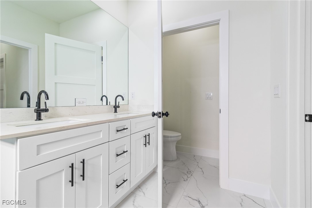 412 Fitch Avenue Lehigh Acres, FL 33972 - Photo 38 of 50 a bathroom with 2 sink toilet and mirror