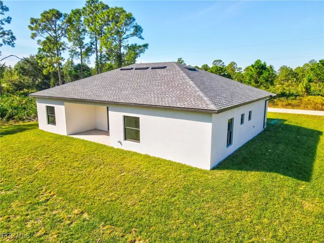 an aerial view of residential houses with outdoor space and trees