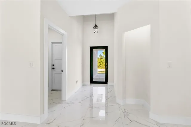 a view of a hallway with wooden floor and a bathroom