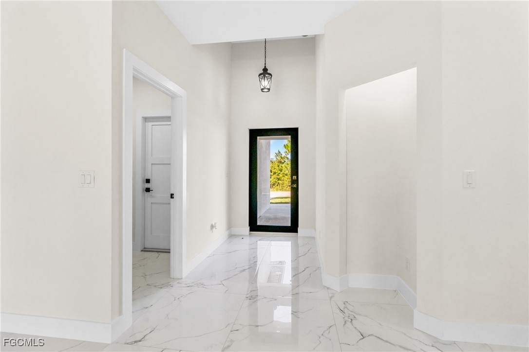 412 Fitch Avenue Lehigh Acres, FL 33972 - Photo 5 of 50 a view of a hallway with wooden floor and a bathroom