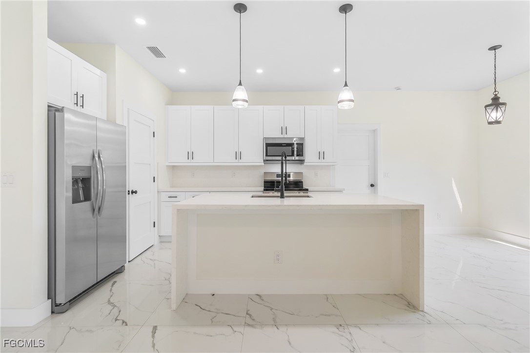 412 Fitch Avenue Lehigh Acres, FL 33972 - Photo 10 of 50 a view of a kitchen with stainless steel appliances granite countertop a refrigerator a oven and a sink