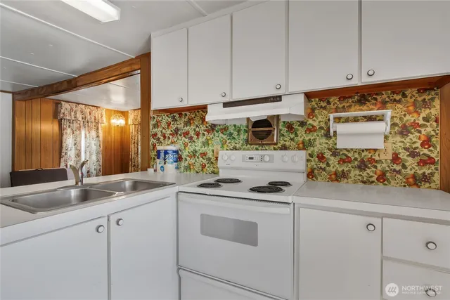 a kitchen with granite countertop white cabinets and white appliances