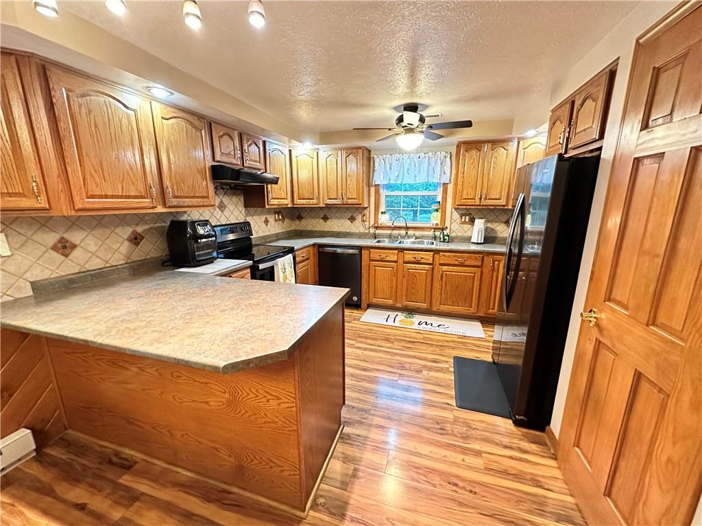 3021 Langley Road Uniontown, PA 15401 - Photo 7 of 28 a kitchen with stainless steel appliances granite countertop a refrigerator a stove top oven a sink dishwasher and wooden cabinets