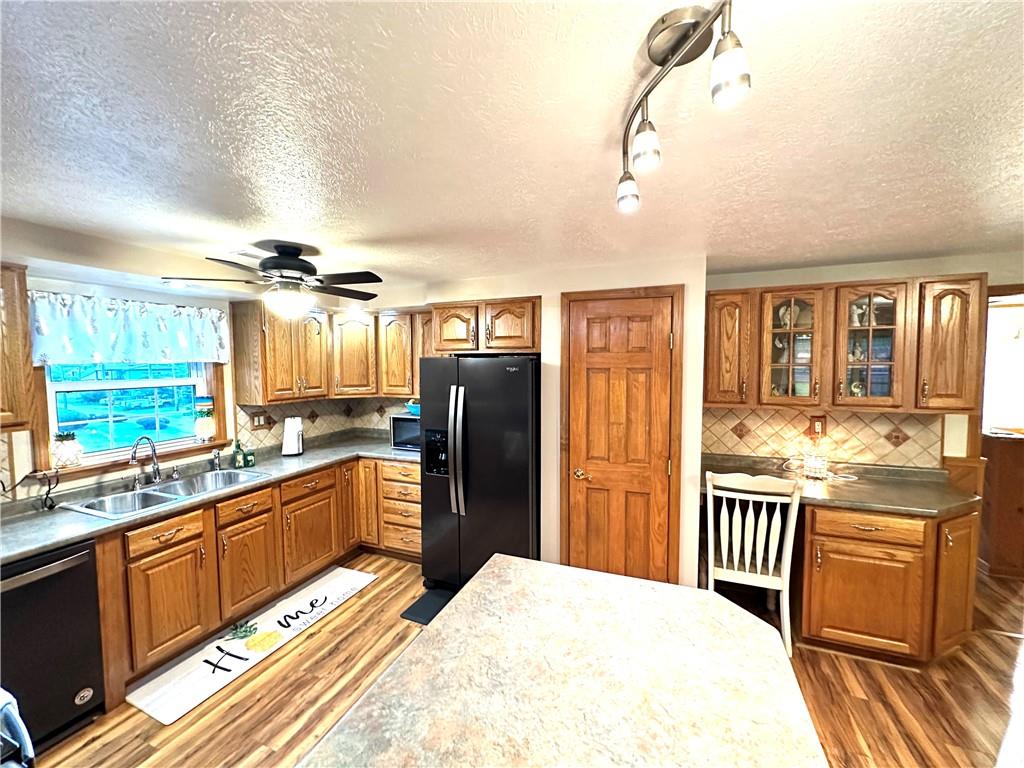 3021 Langley Road Uniontown, PA 15401 - Photo 8 of 28 a kitchen with stainless steel appliances granite countertop a refrigerator a sink dishwasher a stove and white countertops with wooden floor
