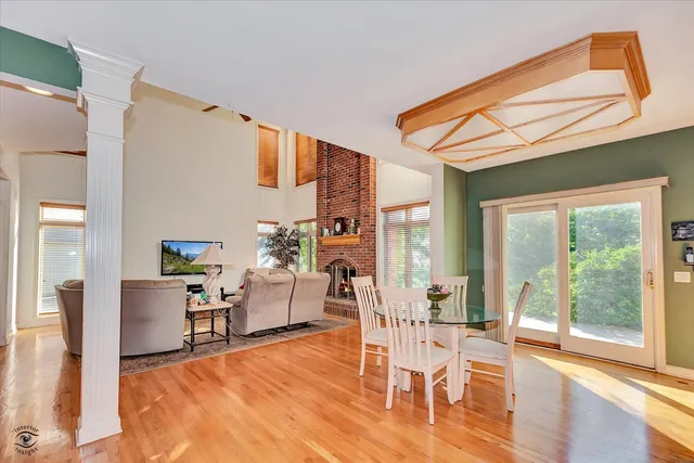 a living room with furniture a large window and wooden floor