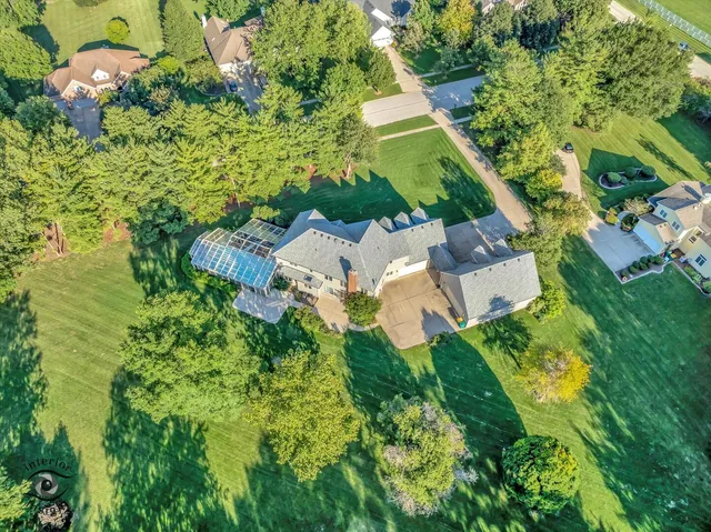 an aerial view of residential house with outdoor space and trees all around