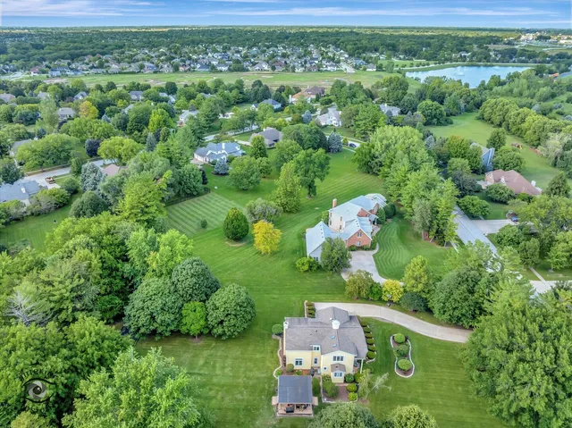 an aerial view of residential houses with outdoor space and trees