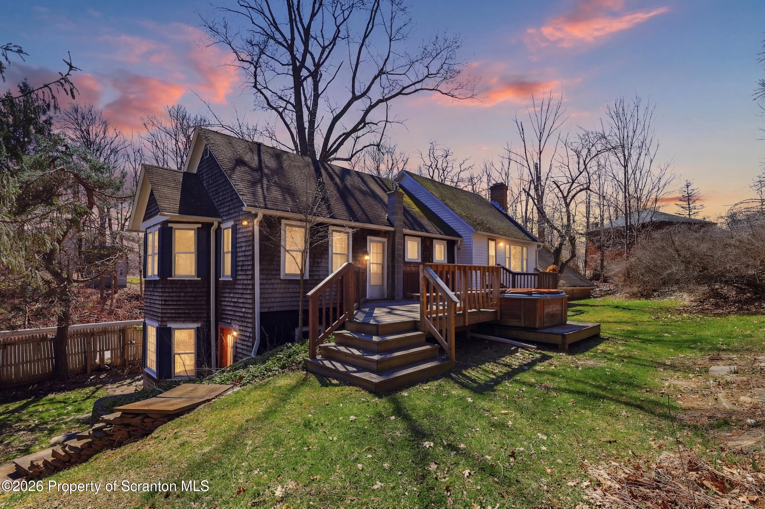 a backyard of a house with wooden fence and large trees