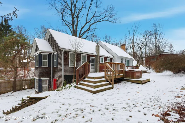a front view of a house with a yard covered in snow