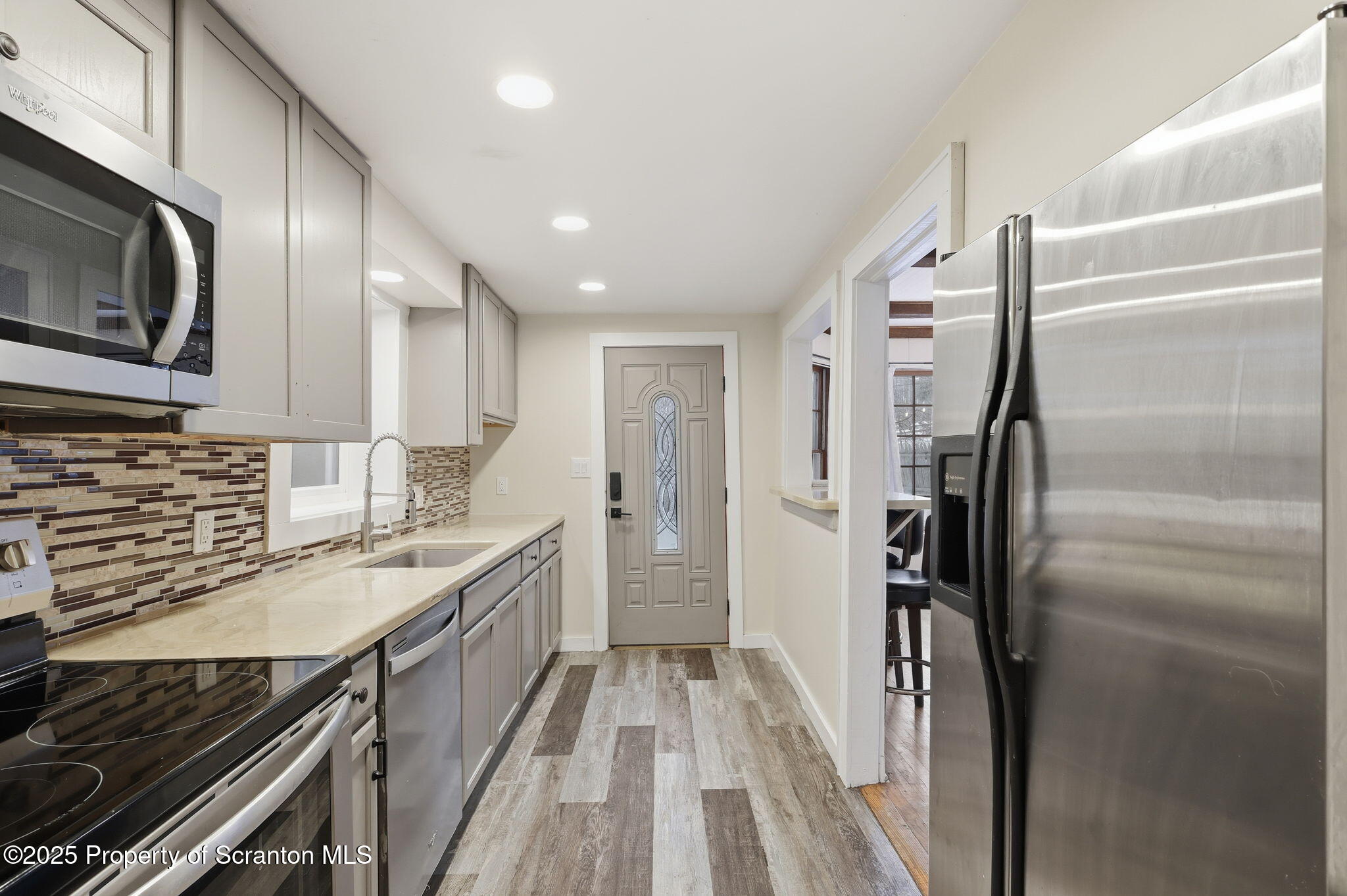 2457 Airport Road Forest City, PA 18421 - Photo 32 of 78 a kitchen with stainless steel appliances granite countertop a refrigerator a stove and a sink with wooden floor