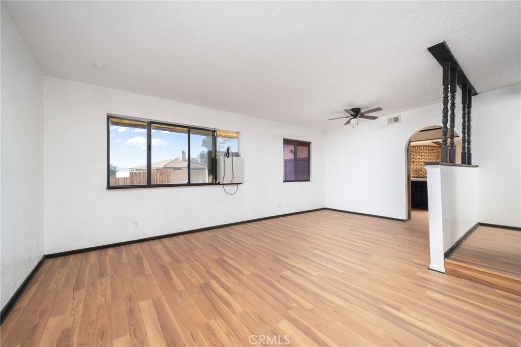 14580 Keota Road Apple Valley, CA 92307 - Photo 14 of 44 a view of an empty room with wooden floor and a window