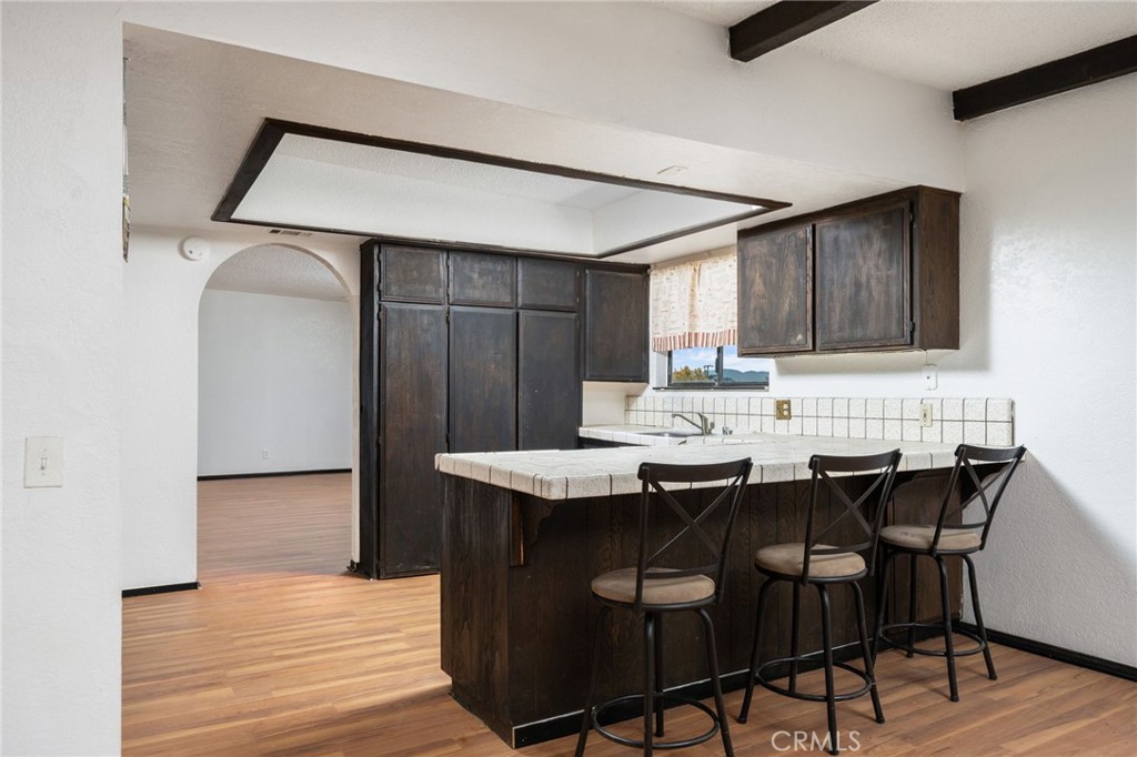 14580 Keota Road Apple Valley, CA 92307 - Photo 17 of 44 a kitchen with stainless steel appliances kitchen island a table chairs in it and wooden floor