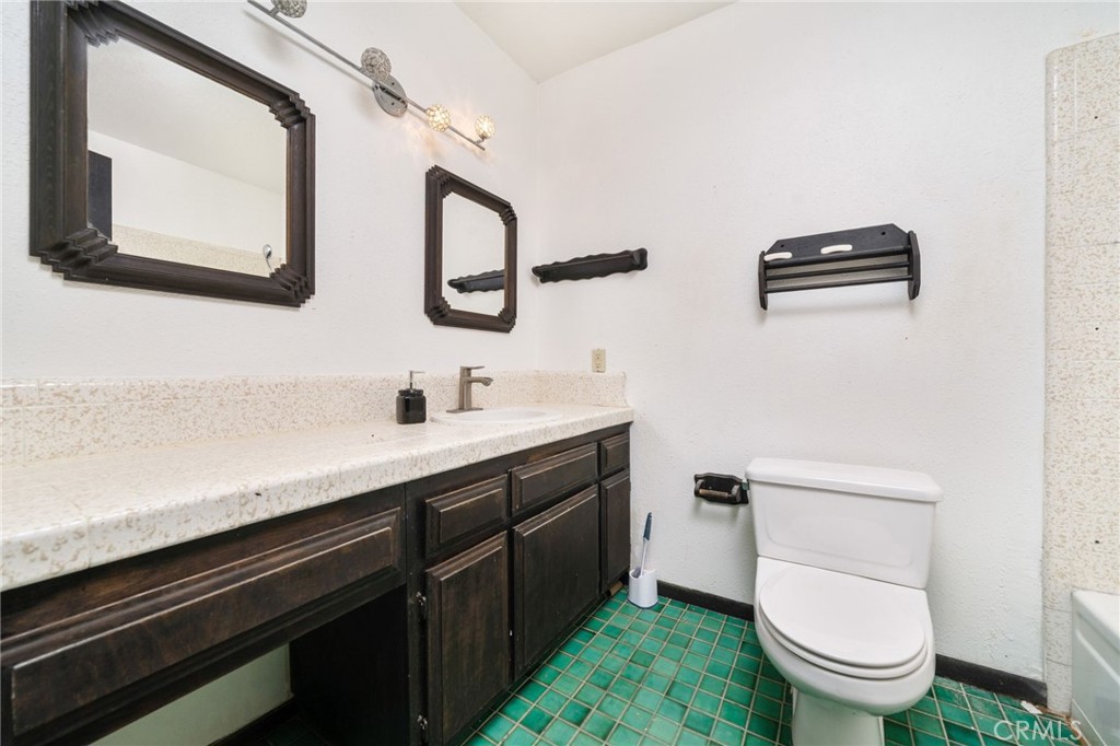 14580 Keota Road Apple Valley, CA 92307 - Photo 22 of 44 a bathroom with a toilet a sink and mirror