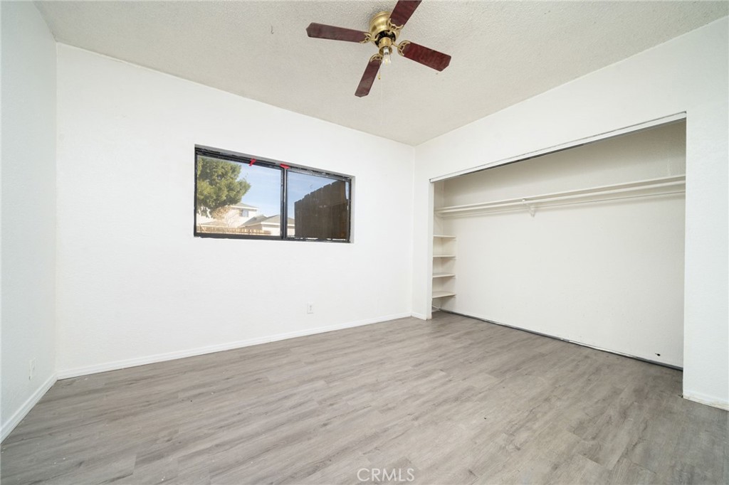 14580 Keota Road Apple Valley, CA 92307 - Photo 26 of 44 an empty room with wooden floor and windows