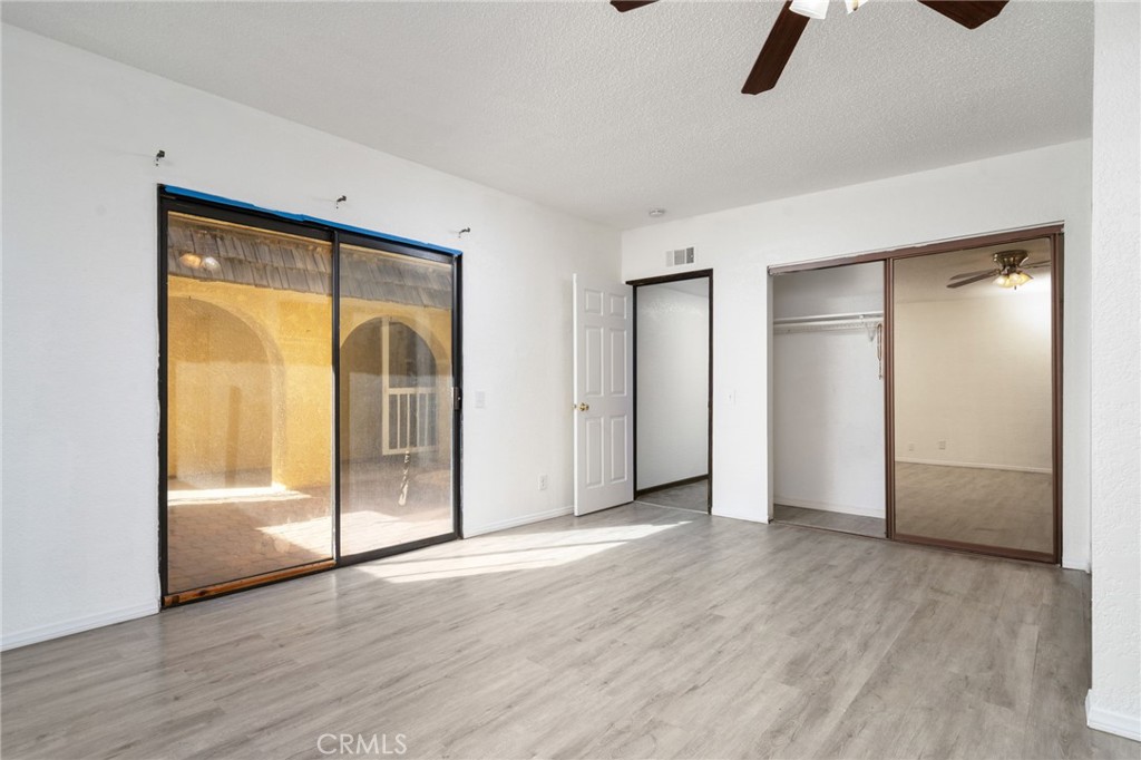 14580 Keota Road Apple Valley, CA 92307 - Photo 30 of 44 an empty room with wooden floor closet and windows