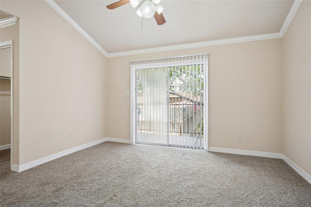 2400 Jupiter Road, Unit B9 Plano, TX 75074 - Photo 8 of 15 Bedroom with ceiling fan, sliding glass door and balcony