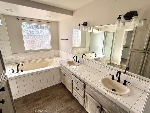 a bathroom with double vanity and a bathtub