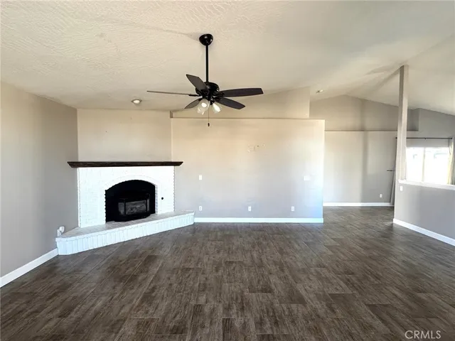 a view of an empty room with a fireplace and a window