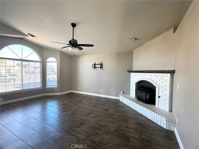 a view of an empty room with a fireplace and a window