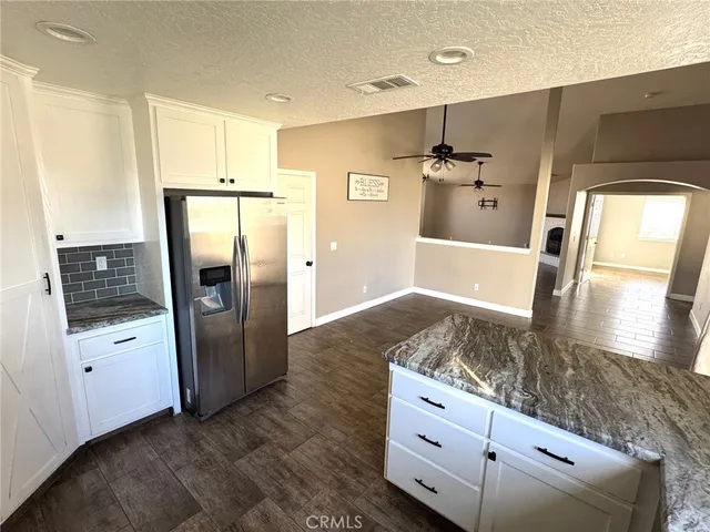 a kitchen with stainless steel appliances granite countertop a refrigerator and a sink