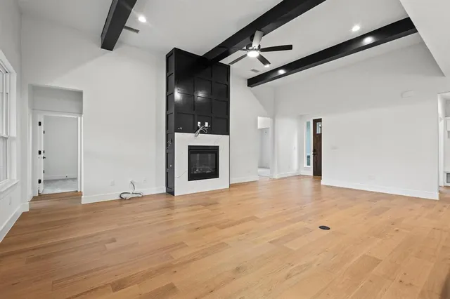 a view of an empty room with a fireplace and a fan