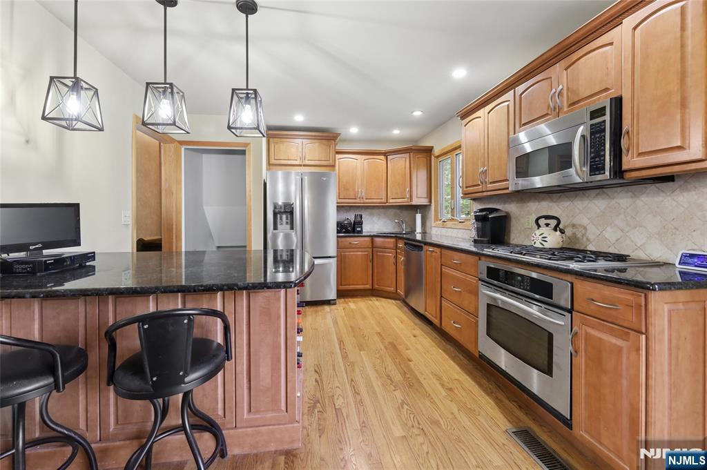 35 Robin Road Wayne, NJ 07470 - Photo 11 of 37 a kitchen with stainless steel appliances granite countertop a sink a stove and a wooden floors