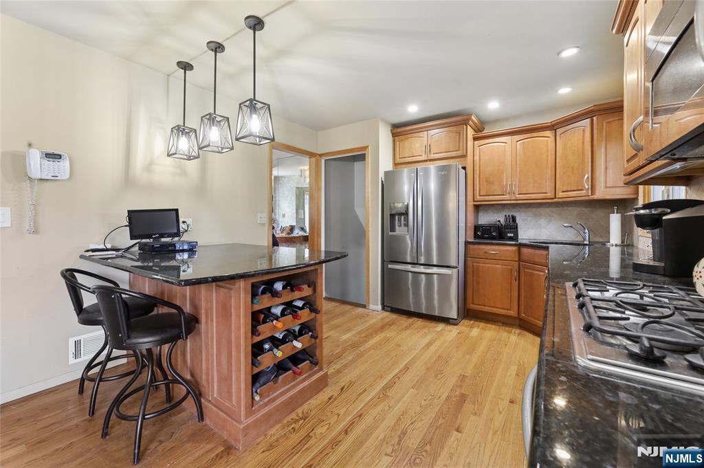 35 Robin Road Wayne, NJ 07470 - Photo 12 of 37 a kitchen with stainless steel appliances granite countertop a sink a stove a refrigerator cabinets and a dining table