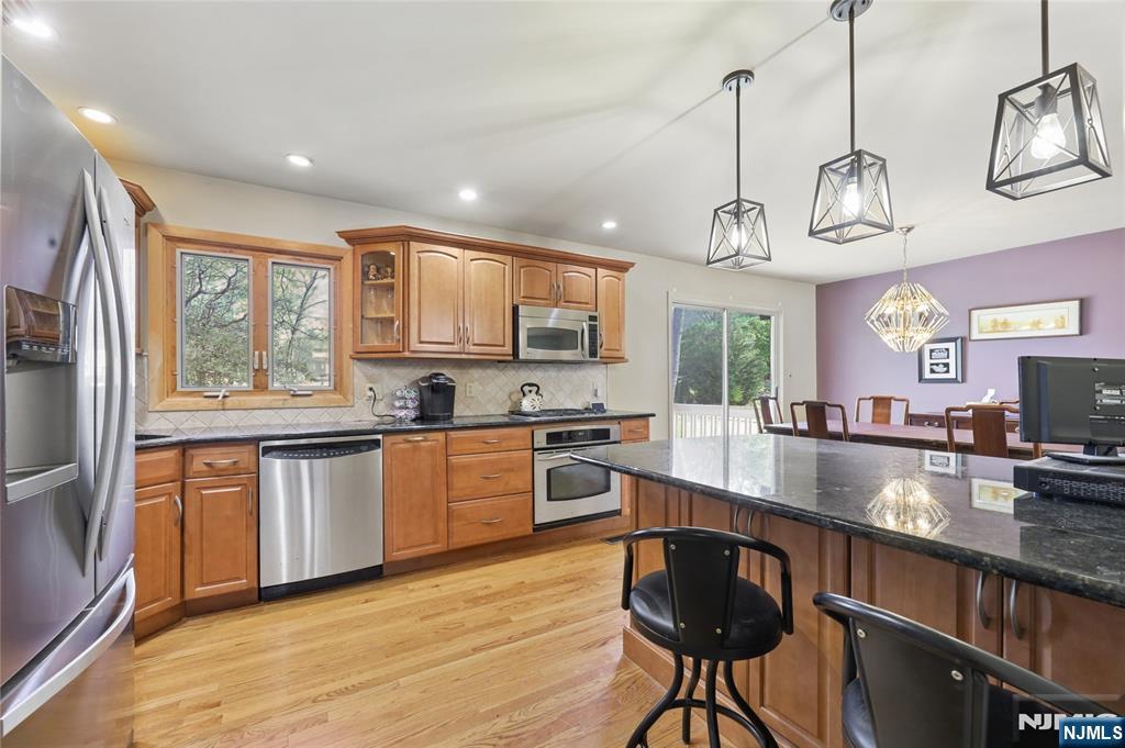 35 Robin Road Wayne, NJ 07470 - Photo 15 of 37 a kitchen with stainless steel appliances granite countertop a sink a stove a refrigerator cabinets and a dining table