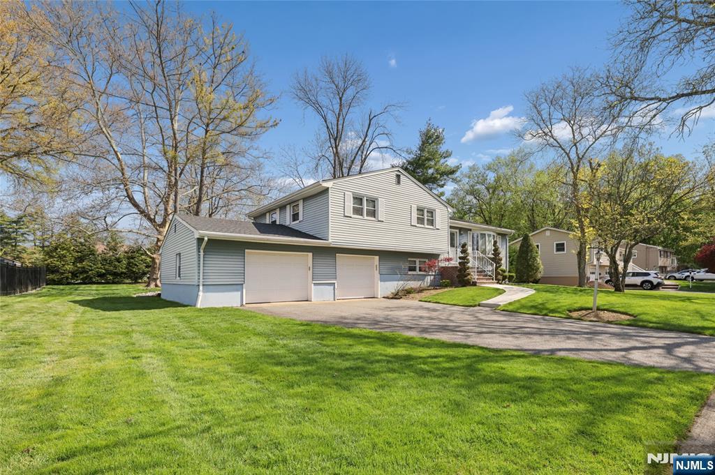 35 Robin Road Wayne, NJ 07470 - Photo 3 of 37 a view of a white house next to a yard with big trees and plants