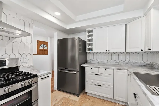 a kitchen with a refrigerator sink and cabinets