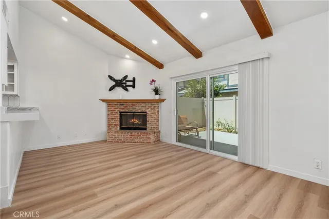 a view of an empty room with a fireplace and a window