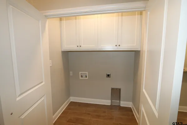 a view of a room with wooden floor chandelier fan and windows
