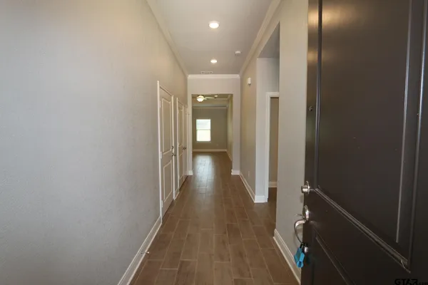 a view of an empty room with a window and wooden floor