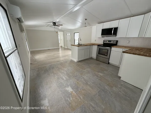 a kitchen with granite countertop a refrigerator a stove top oven a sink and dishwasher