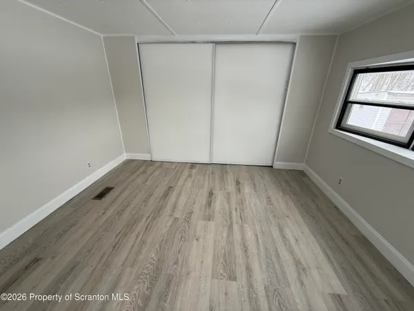 a view of a room with wooden floor and white walls