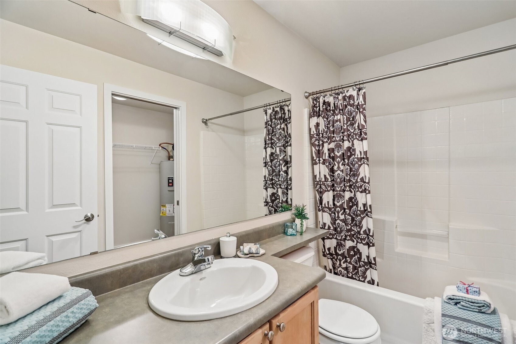 18930 Bothell Everett Highway, Unit E301 Bothell, WA 98012 - Photo 15 of 28 a bathroom with a sink toilet a mirror and shower curtain