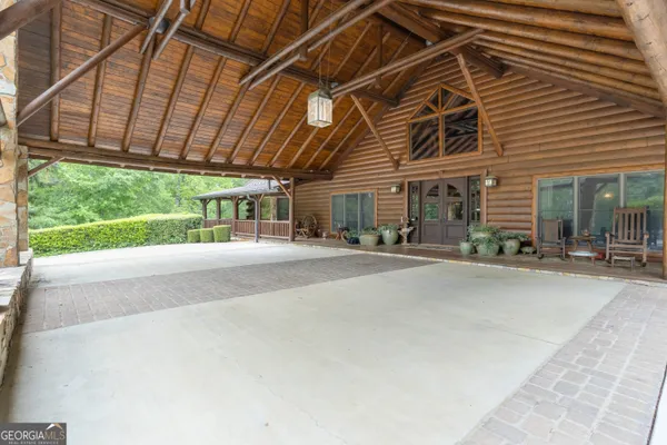 a bedroom with a bed a chair and large mirror with the potted plants